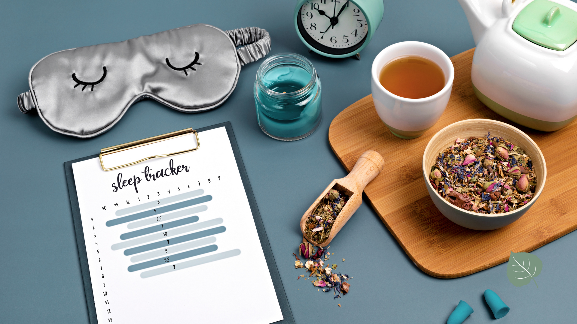Sleep tracker, eye mask, tea, and candle on a blue surface.