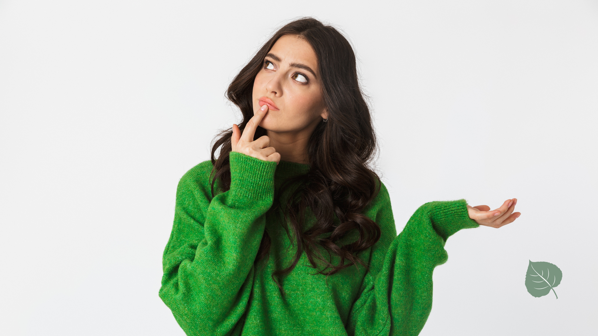 A woman in a green sweater is looking up and shrugging her shoulders.