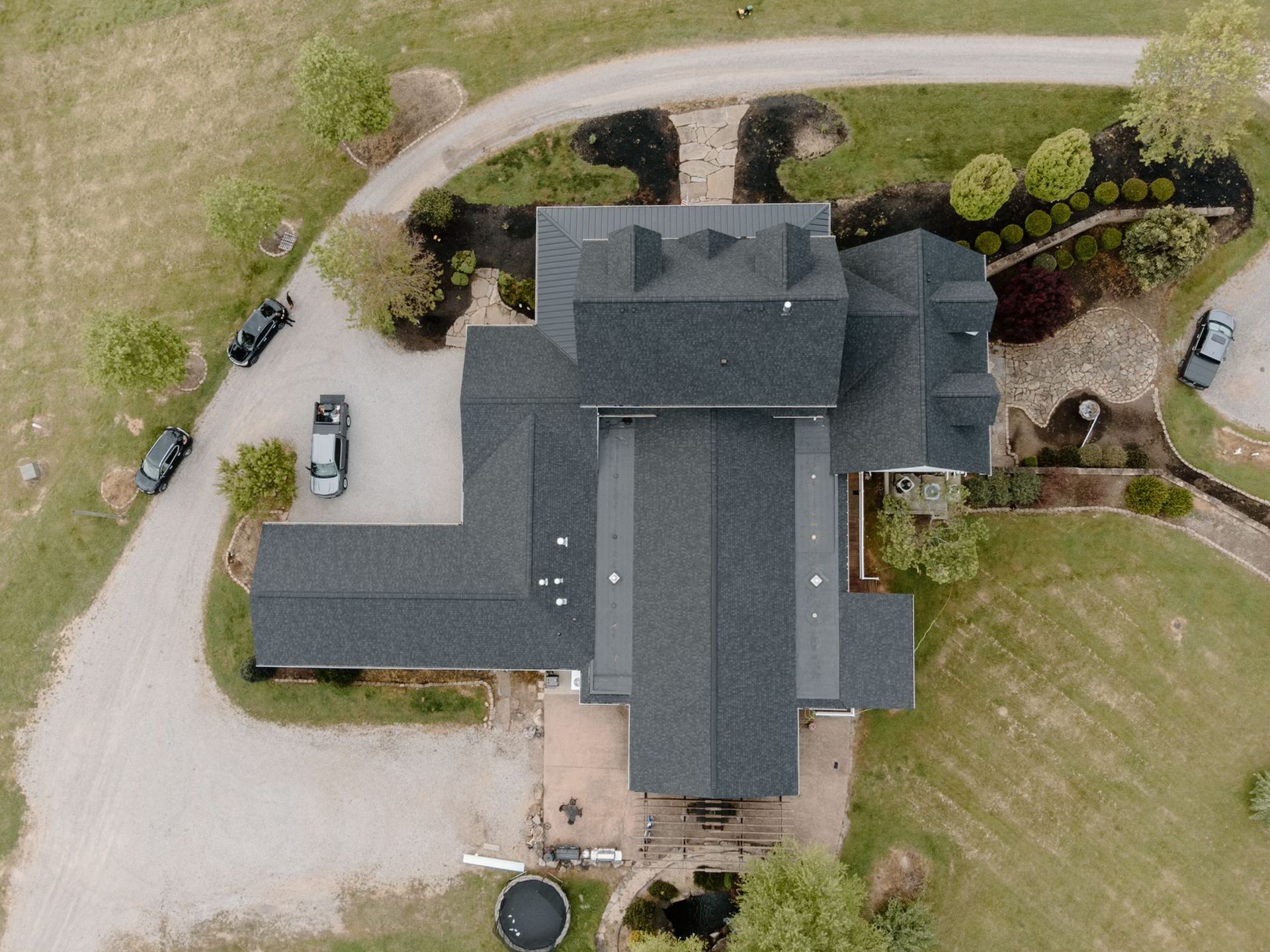 An aerial view of a large house with a black roof