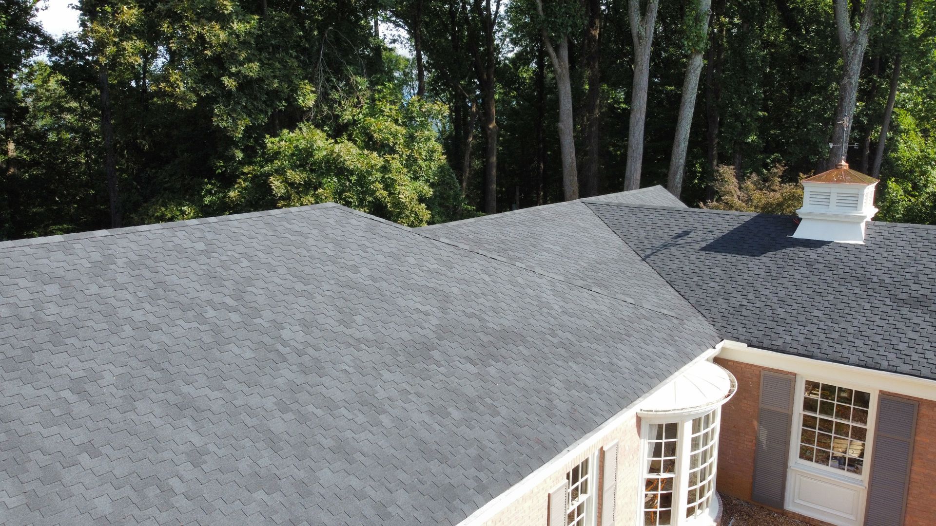 An aerial view of a house with a black roof