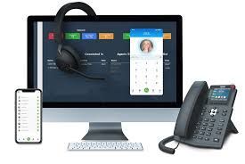 Desktop computer, phone, headset, and smartphone displaying a call center interface.
