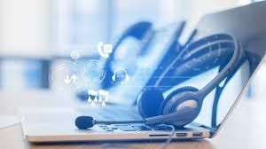 Headset on a laptop, call center setup, glowing digital icons.