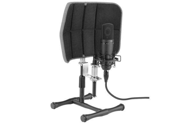 A microphone is sitting on a stand with a shield behind it.