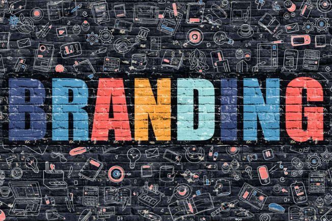 The word branding is written in colorful letters on a brick wall.