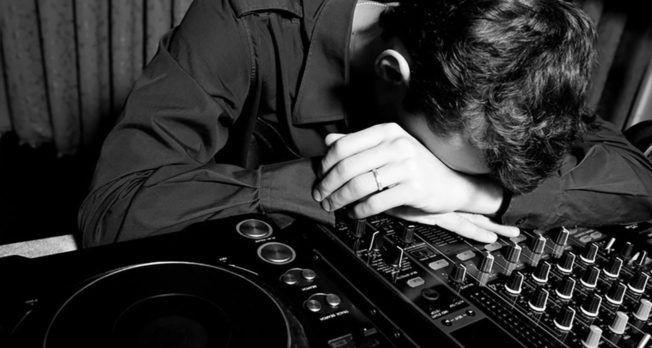 A woman is laying her head on a mixer in a black and white photo.