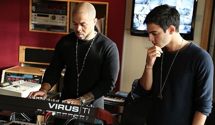 Two men are playing a keyboard that says virus ti on it