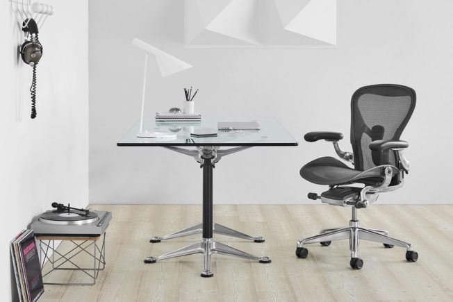 A chair is sitting next to a desk in a room.