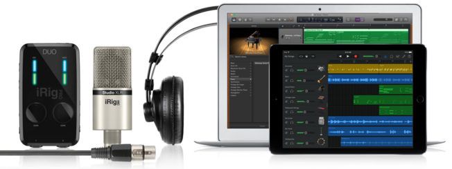 A microphone and headphones are connected to a laptop and a tablet.