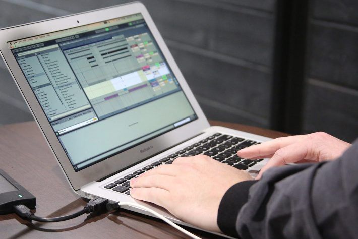 A person is typing on a macbook air laptop