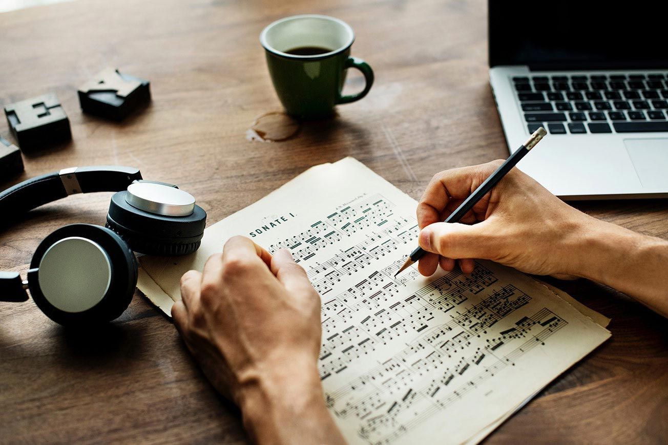 desk with laptop and sheet music