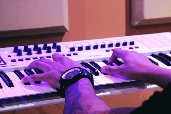 A person is playing a keyboard with a watch on their wrist.