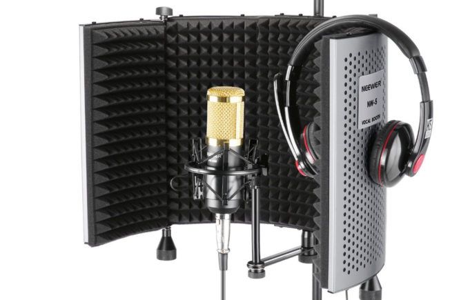 A microphone and headphones are sitting next to each other on a stand.