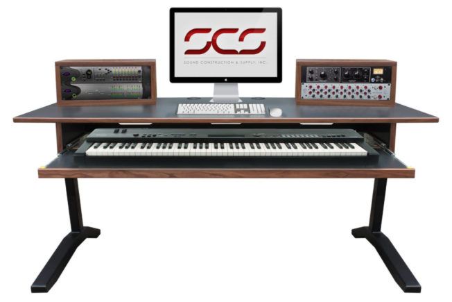 A desk with a keyboard and a computer on it.