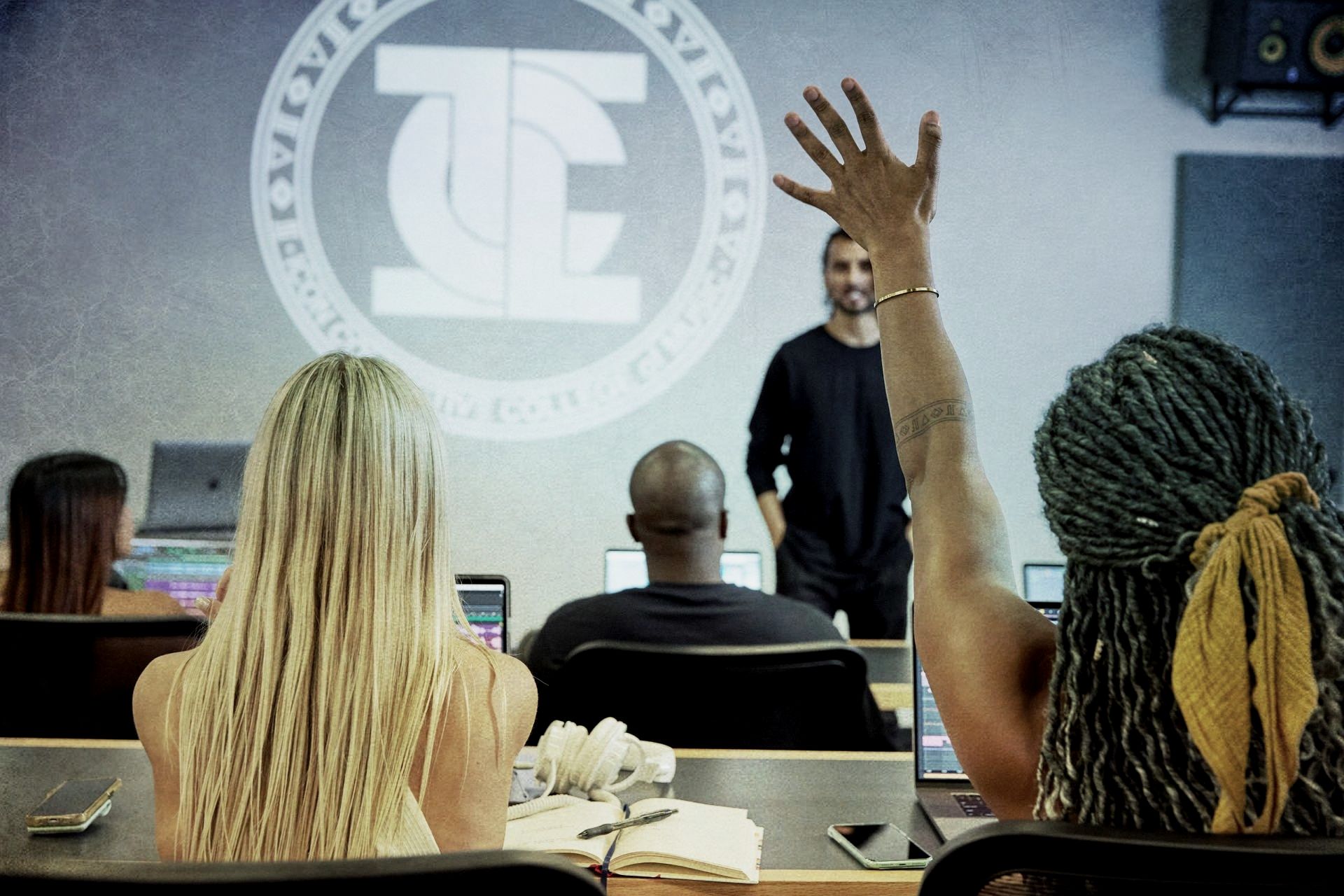 A woman raises her hand in a classroom.