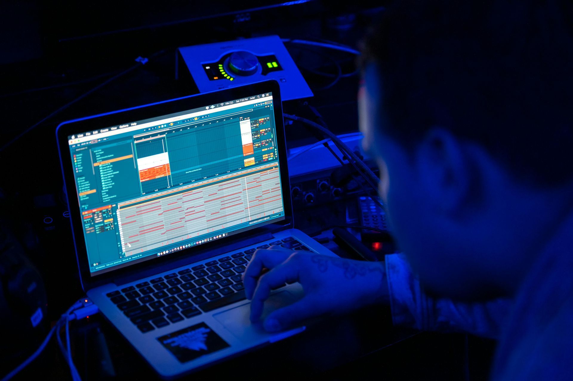Person producing music at laptop from home