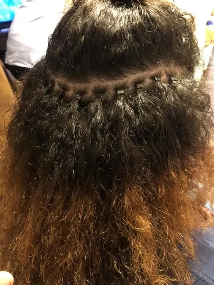 Back view of wavy brown hair with a braided section across the crown