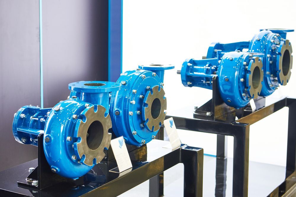 Dos bombas industriales azules en expositores.