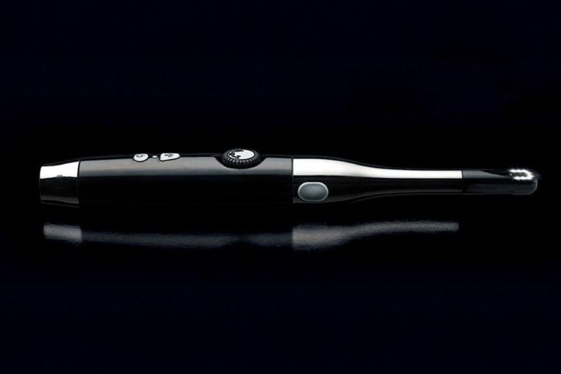 Black handheld device with silver accents and buttons, shown in side view on a dark background