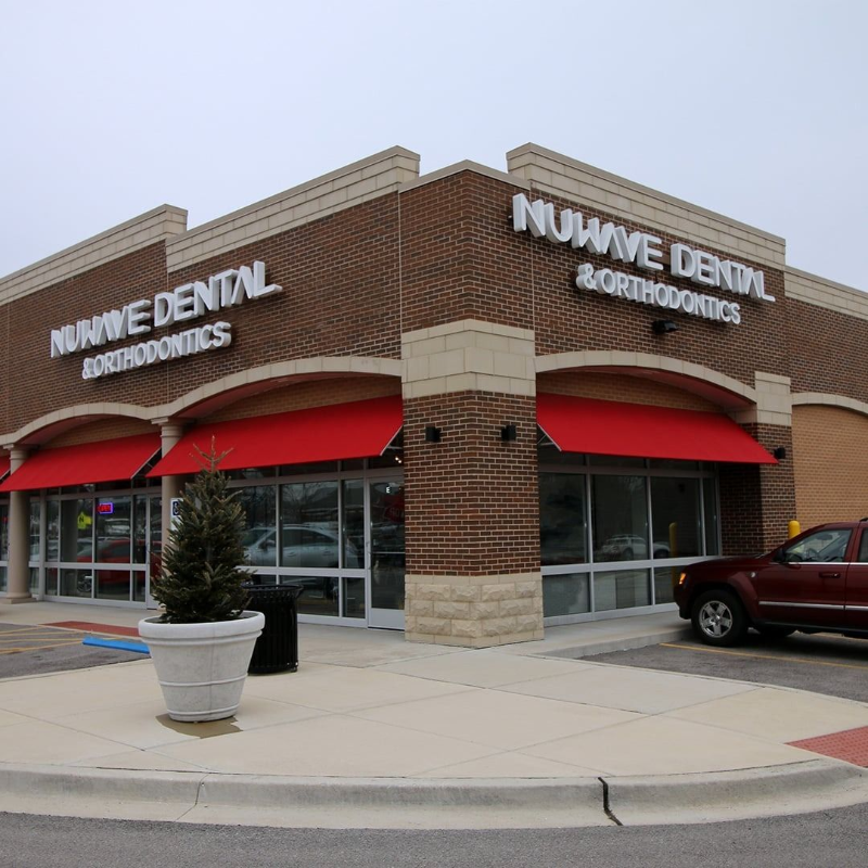 Nuvive Dental and Orthodontics storefront with red awnings in a brick strip mall