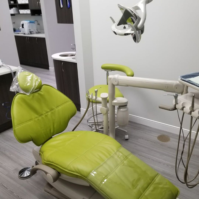 Empty lime-green dentist chair in a modern dental exam room