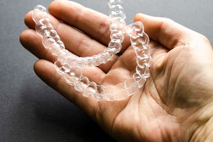 Clear plastic chain held in a hand on a dark background