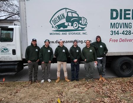 Moving company crew standing in front of a white truck with logo and contact info.