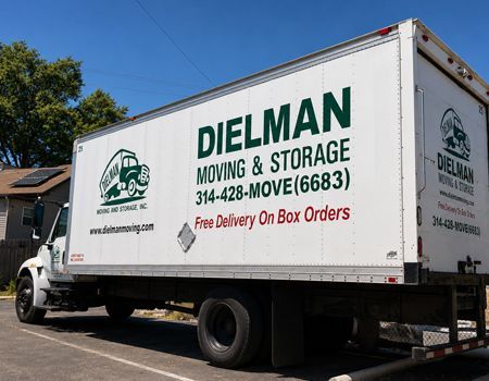 White moving truck for Dielman Moving & Storage parked on a street in daylight