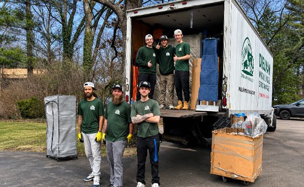 Five volunteers unload supplies from a truck at a roadside donation site.