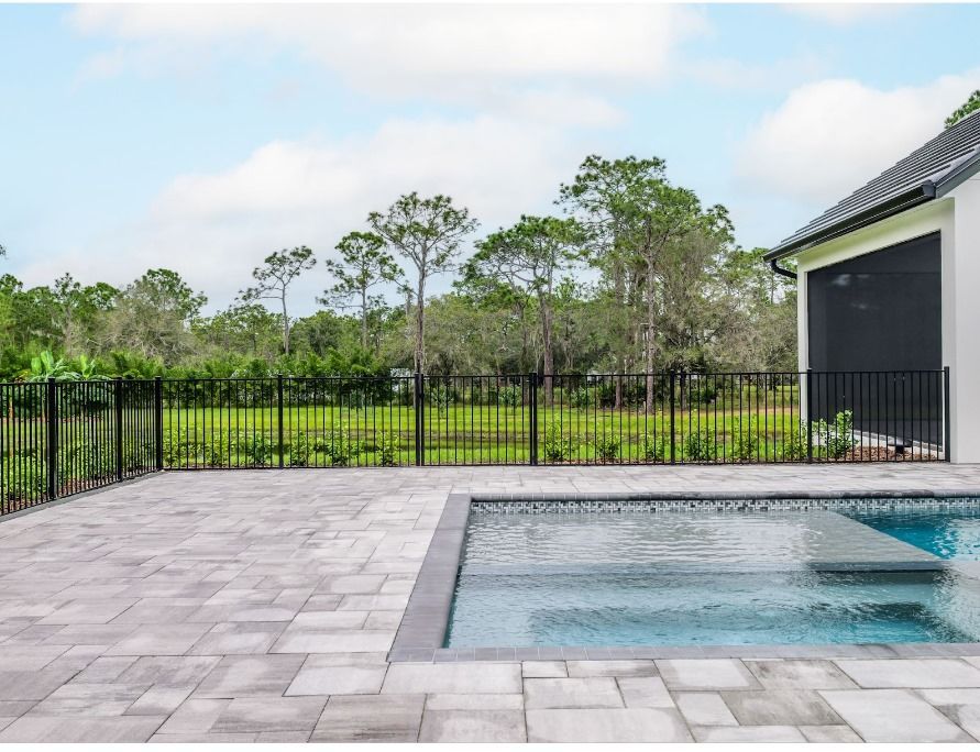 A metal rail fence bordering a beautiful swimming pool area