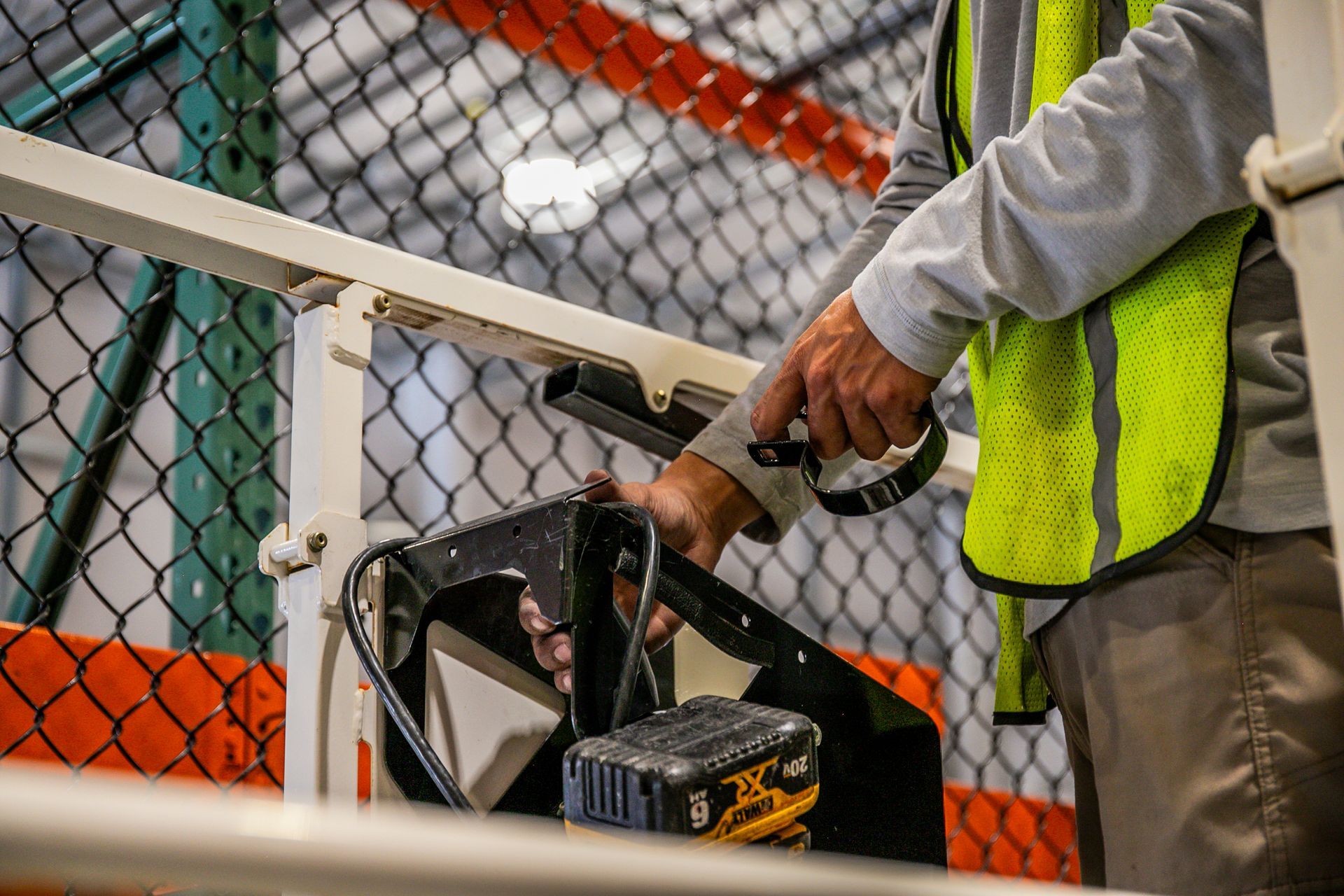 man working on a chain link fence