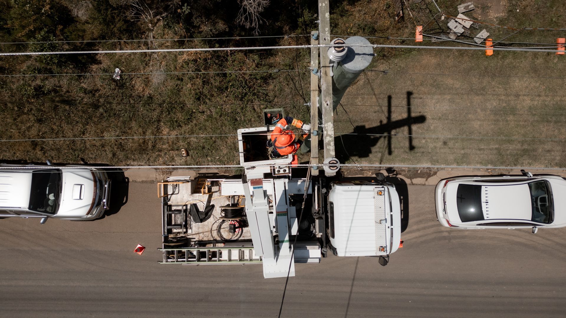Electrician Shellharbour – aerial view of electrician in hi-vis working on a power pole from an elevated bucket truck