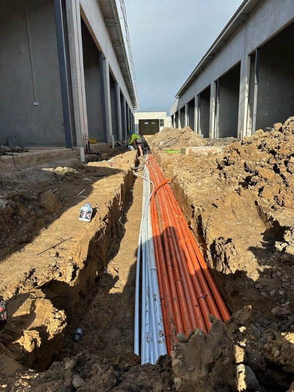 A Bunch of Pipes Are Laying in the Dirt — John McEwan Electrical In Dapto, NSW