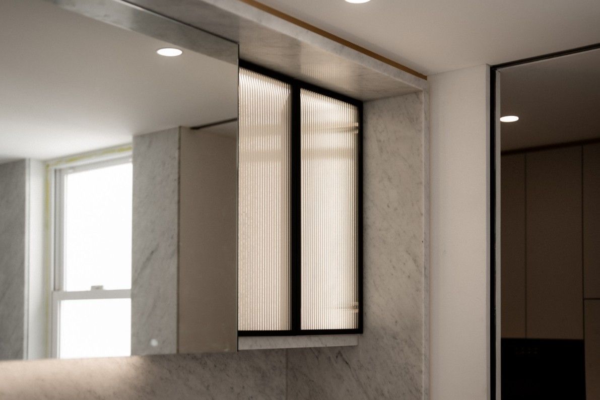 A Bathroom With a Large Mirror and a Window — John McEwan Electrical in Fairy Meadow, NSW