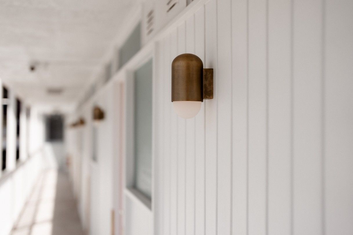 A Hallway With White Walls and a Light on the Wall — John McEwan Electrical in Kiama, NSW