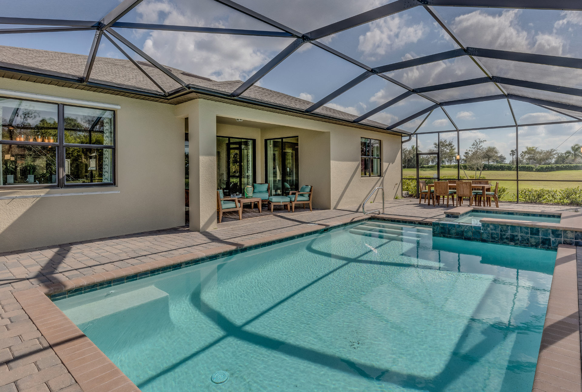 There is a large swimming pool in the backyard of a house.