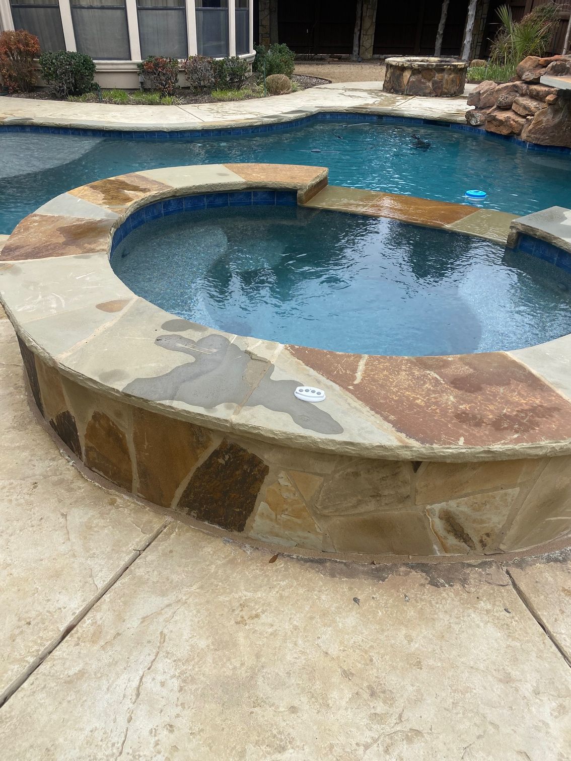 A large swimming pool with a hot tub in the middle of it.
