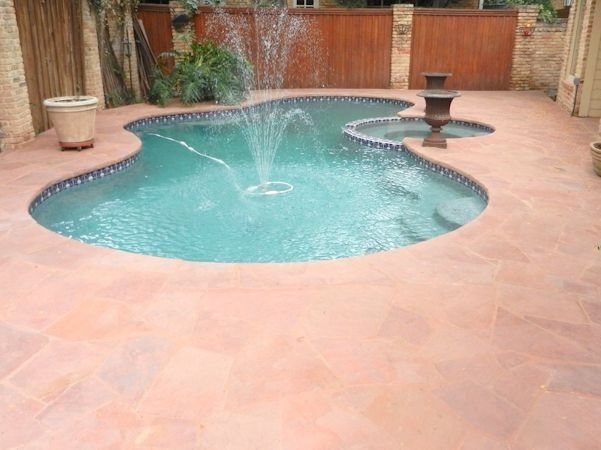 A large swimming pool with a fountain in the middle of it.