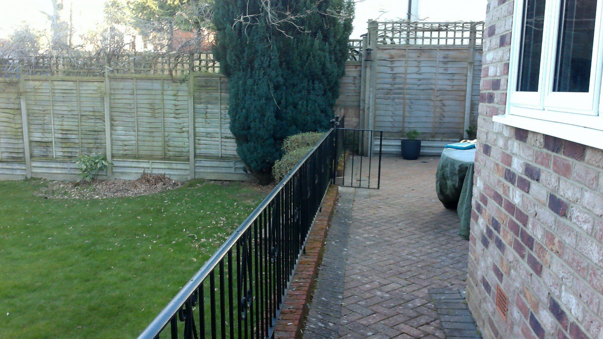 A brick building with a fence and a brick walkway