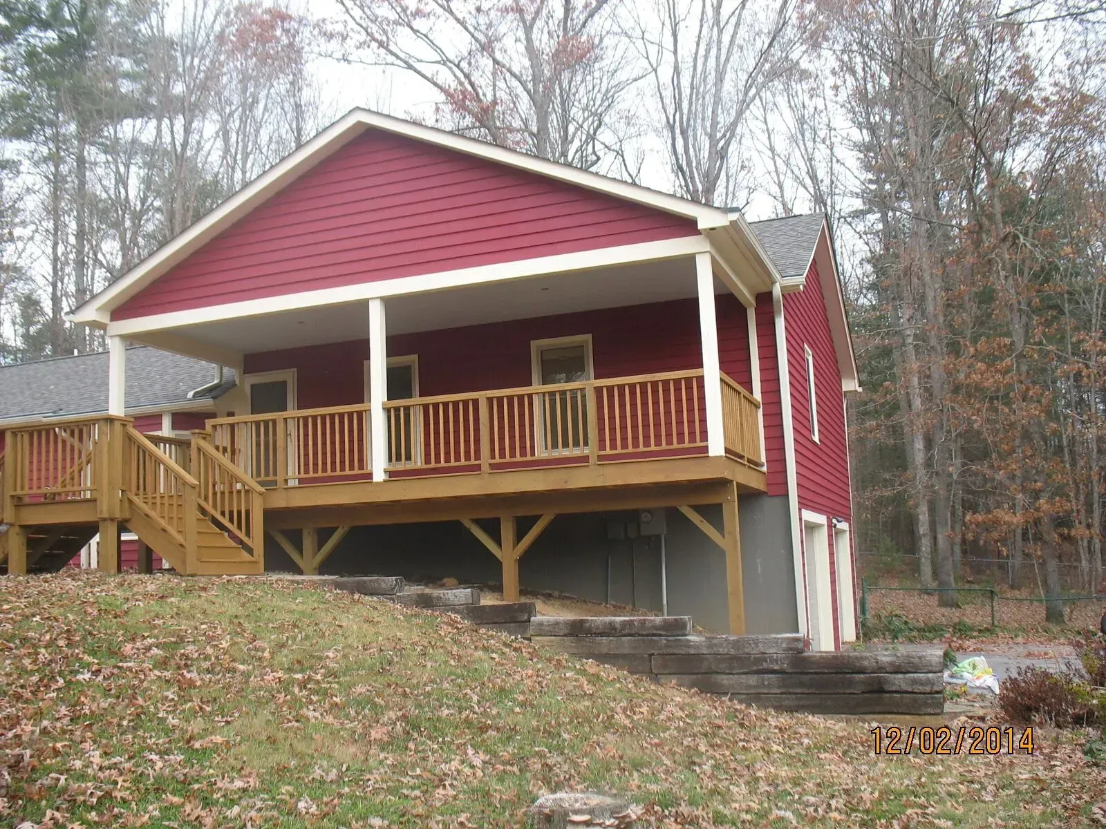 A red house with a large porch and stairs