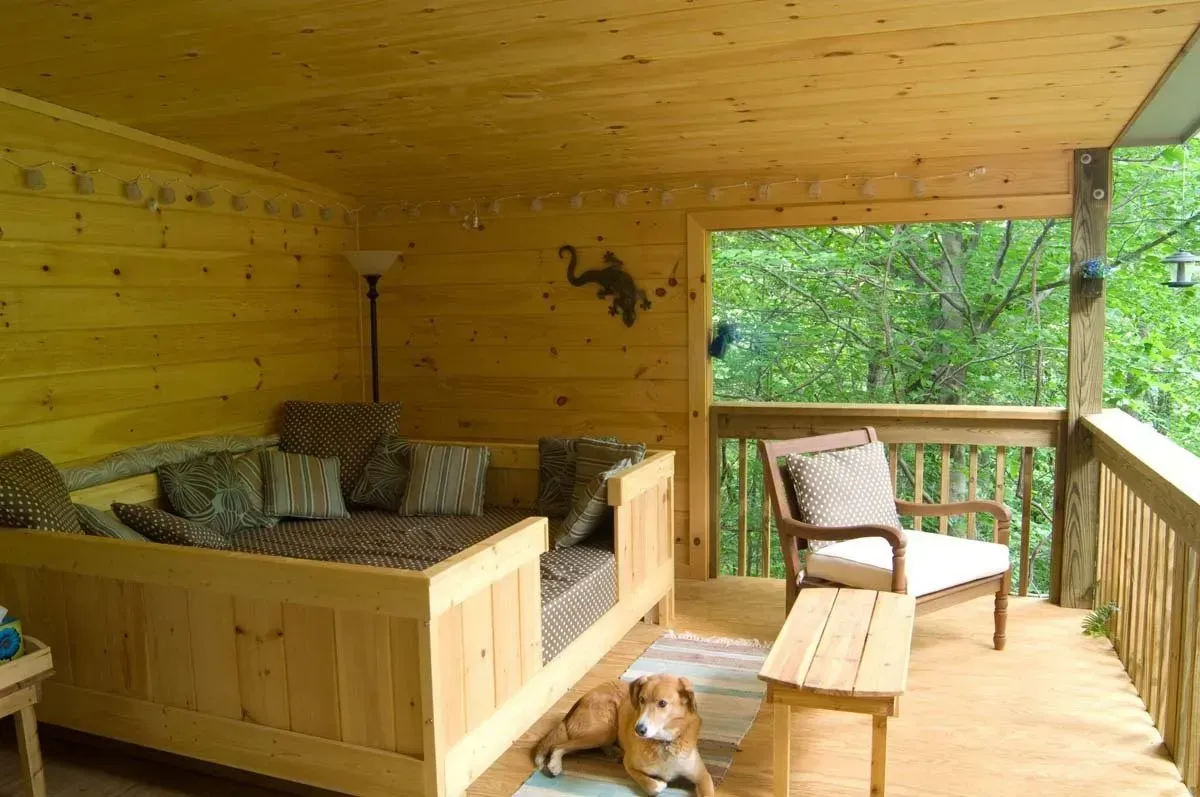 a room full of custom wood additions of a custom day bed under a covered porch in Asheville, NC.