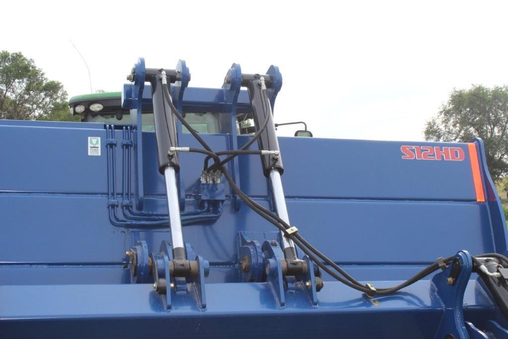 A blue scraper with hydraulic cylinders