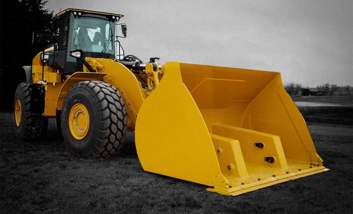 A yellow bulldozer with a large rollout bucket is parked in a field.