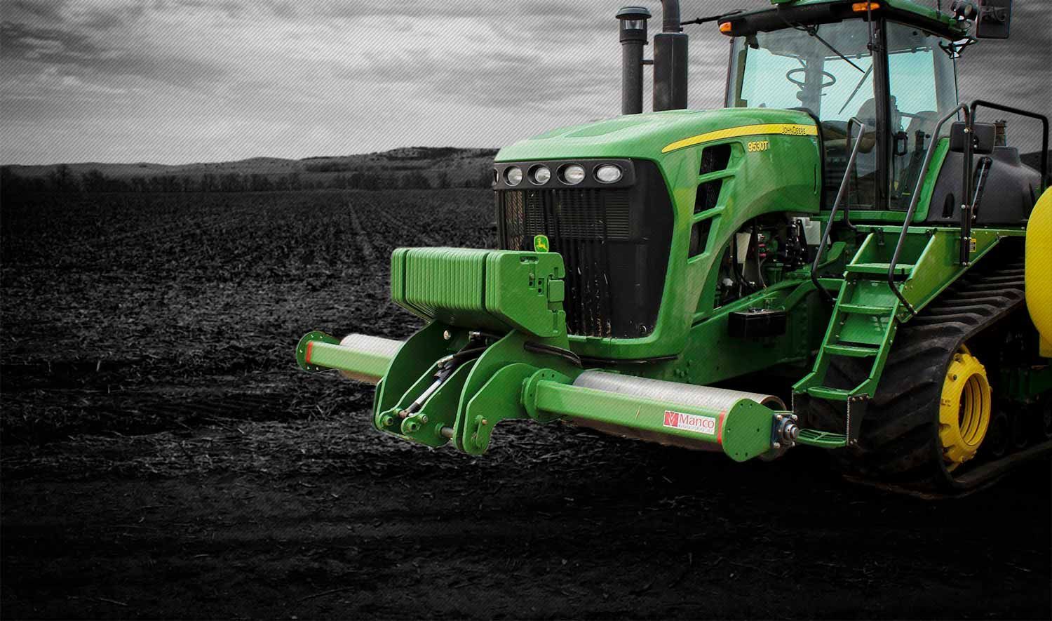 A green and yellow John Deere tractor with a Manco stalk roller.