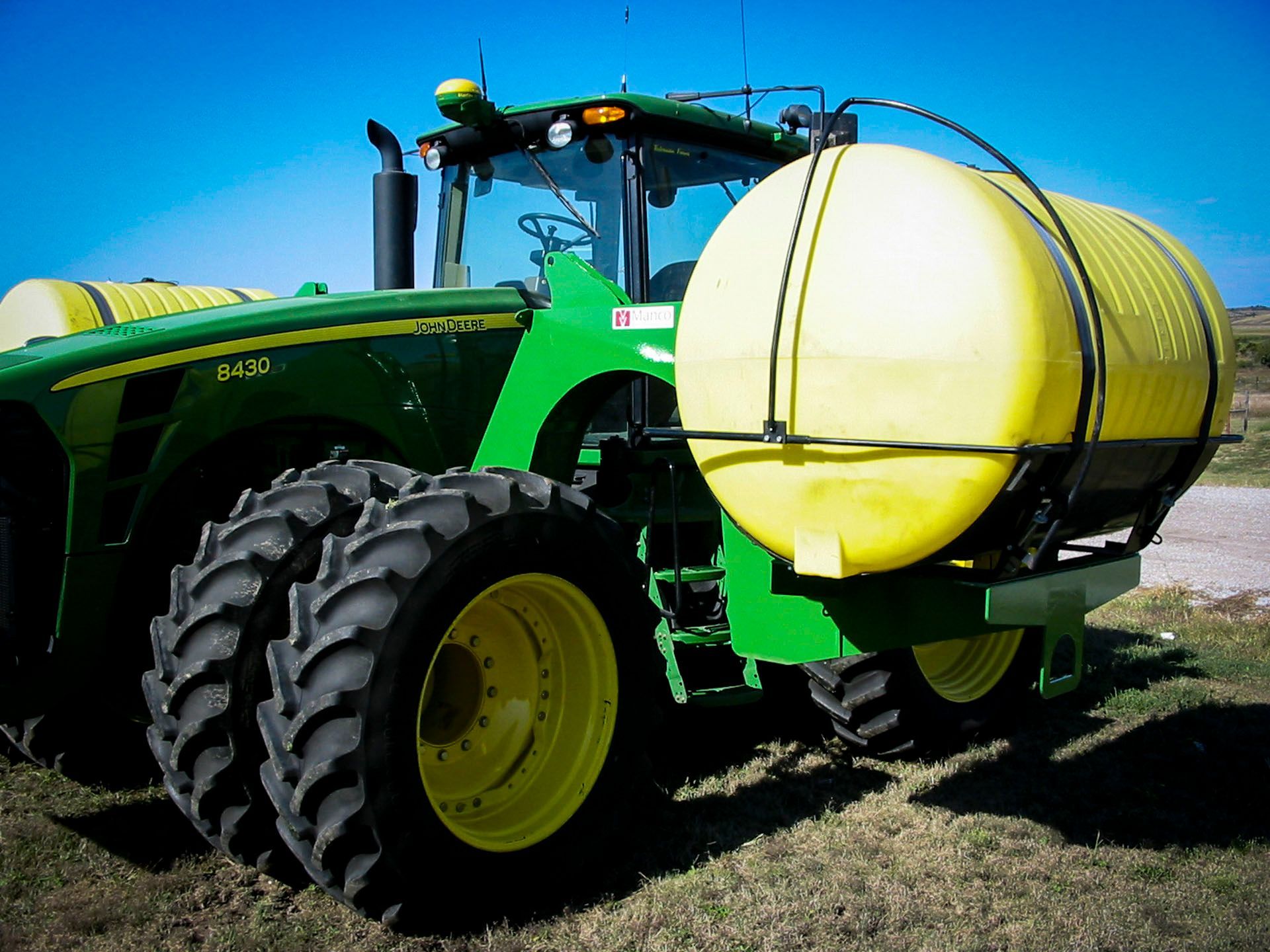 A john deere tractor with a yellow tank attached to it
