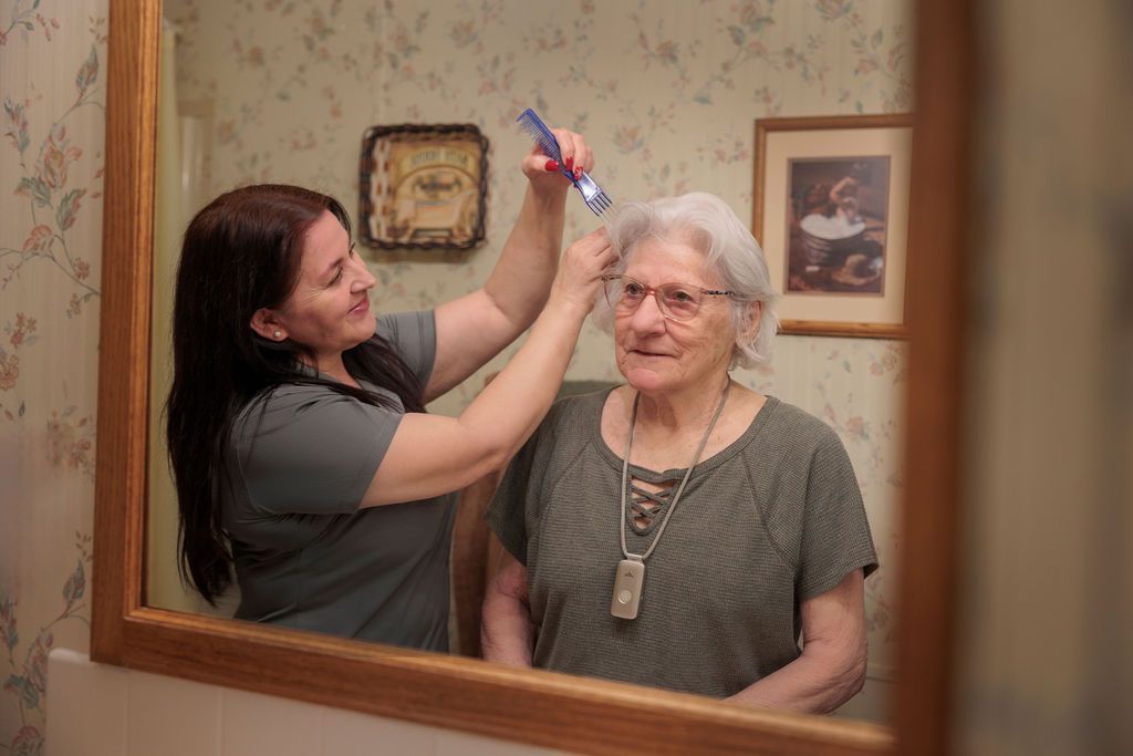 Two women are ironing clothes in a living room.