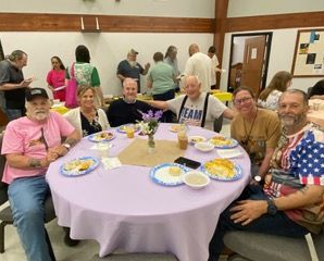 A group of women are posing for a picture at a table.