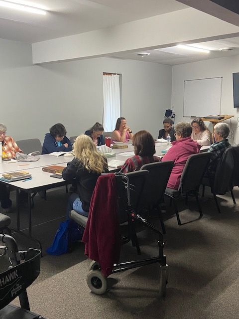 A group of people are sitting around a table in a room.