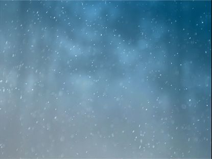Snow is falling in the night sky on a blue background.