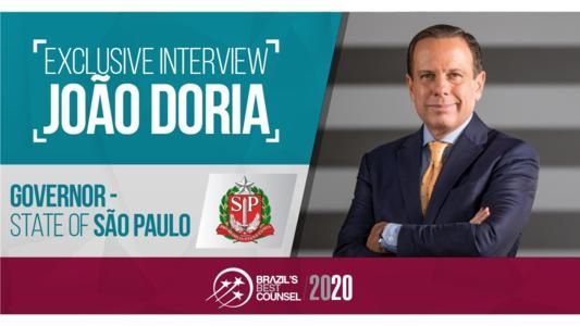 João Doria, Governor of São Paulo, in an exclusive interview. Includes logo and text on a maroon background.