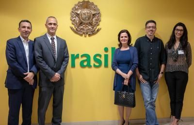 Five people standing in front of a yellow wall with 